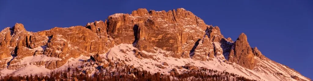 Falaises dentelées des Dolomites baignées d'un manteau rose au crépuscule