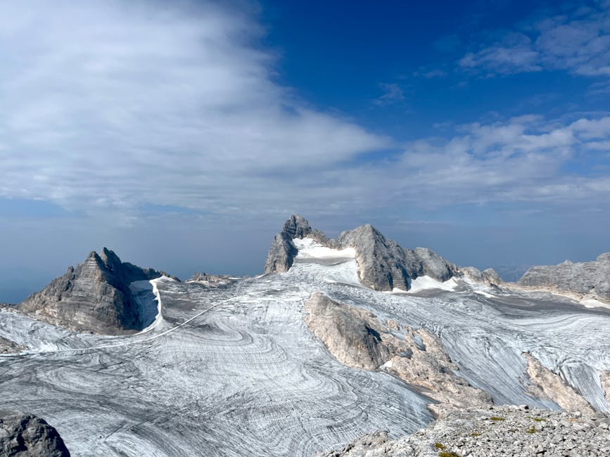 Glacier étendu et pics rocheux des Dolomites sous ciel partiellement nuageux