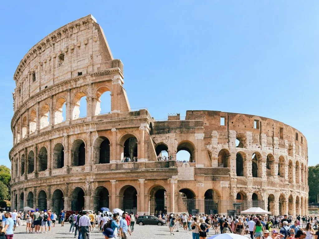 Façade du Colisée à Rome avec foule et ciel bleu lumineux