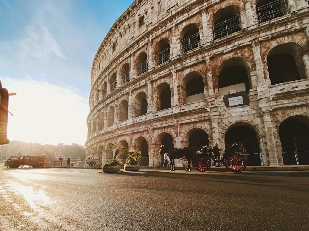 Façade du Colisée à Rome au lever du soleil, calèche visible