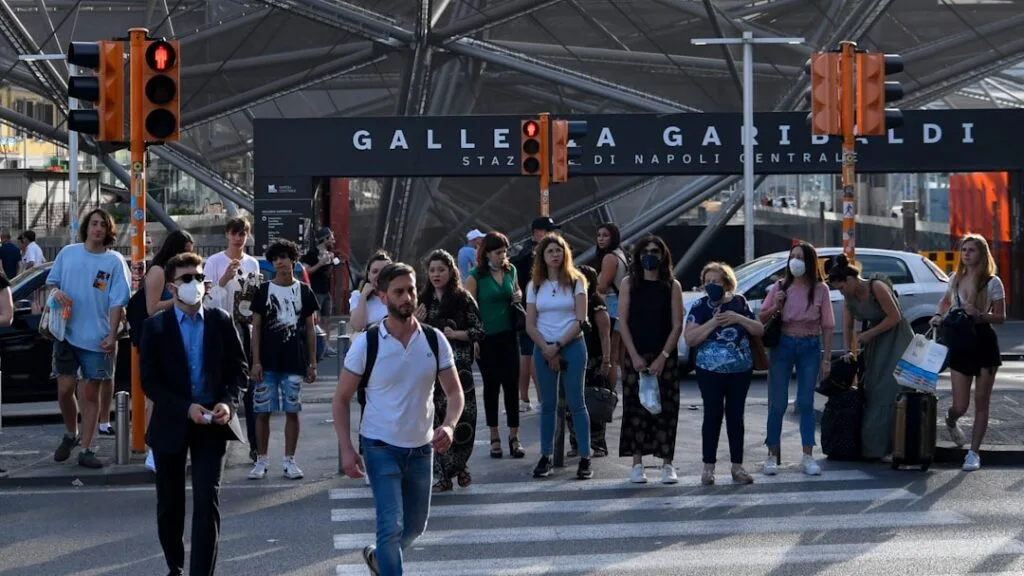 Foule traversant un passage piéton devant la gare Garibaldi.