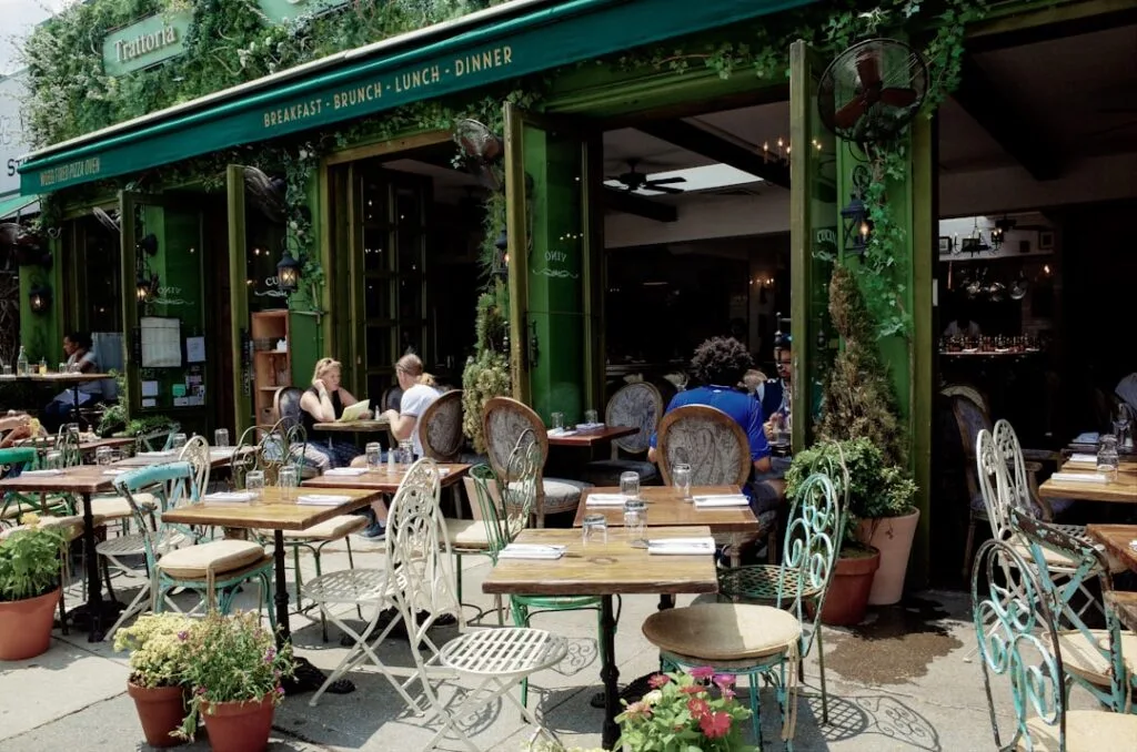 Terrasse d'une trattoria à Rome aux tables en fer forgé vert
