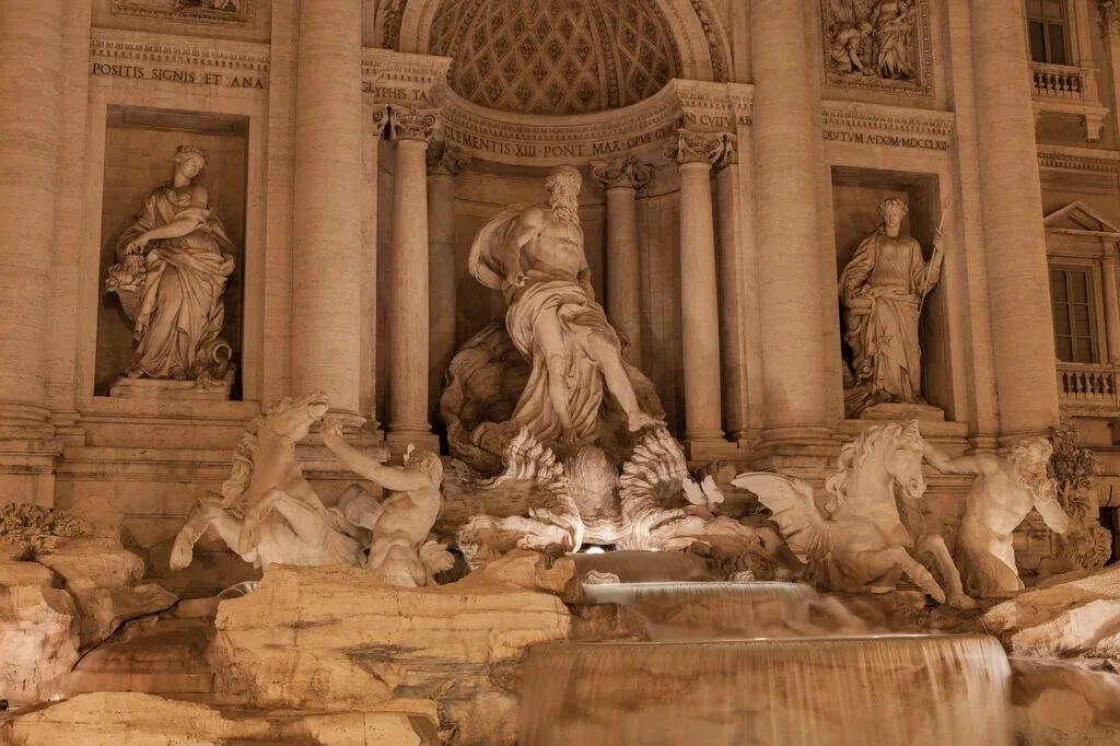 Fontaine de Trevi illuminée la nuit, sculptures baroques et cascades