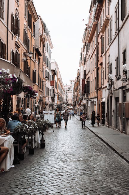 Rue pavée animée à Rome, cafés et passants entre immeubles colorés