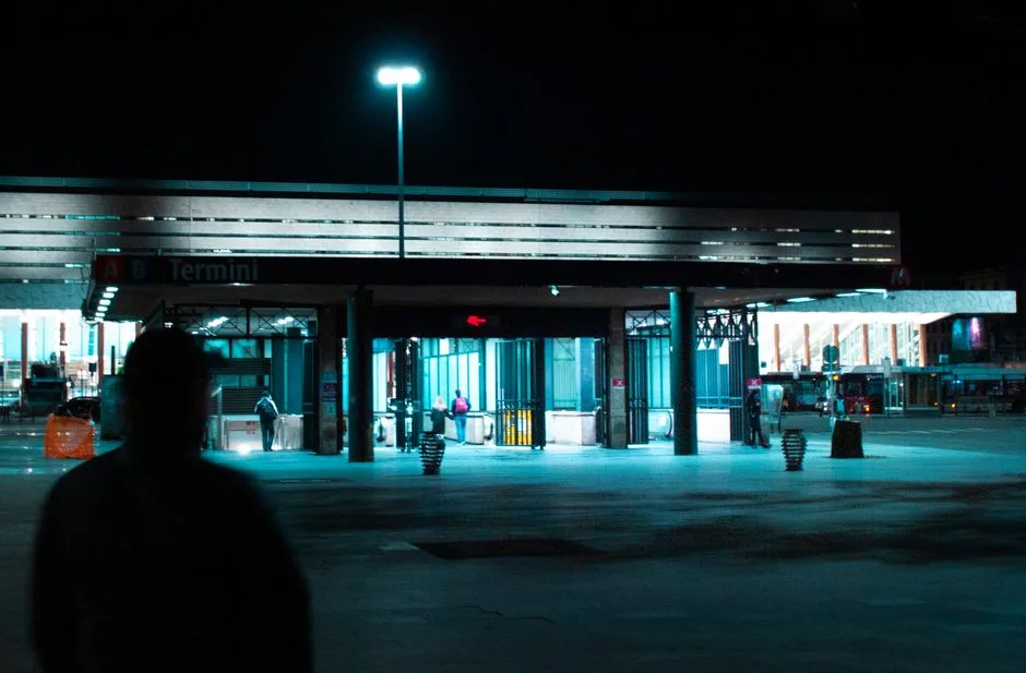 Entrée de la gare Termini de Rome la nuit, silhouettes floues