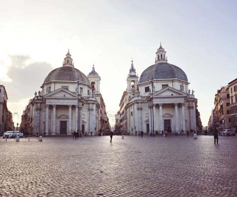 Églises jumelles sur la Piazza del Popolo à Rome au crépuscule.