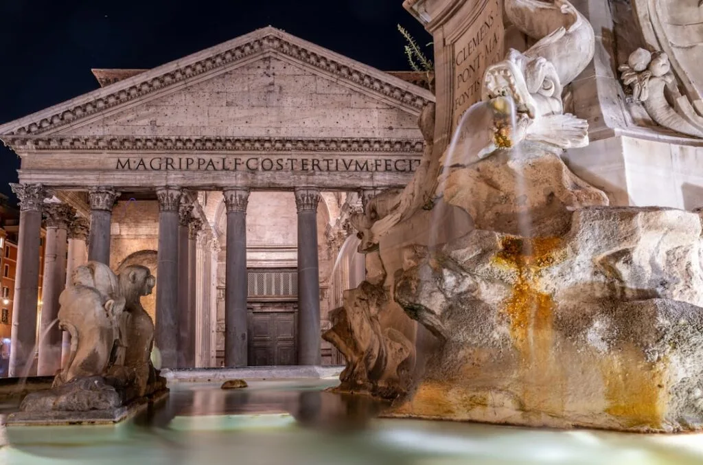 Fontaine illuminée devant le Panthéon de Rome la nuit.