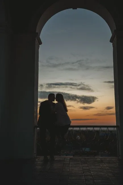Couple silhouetted kissing at sunset in Piazza del Duomo