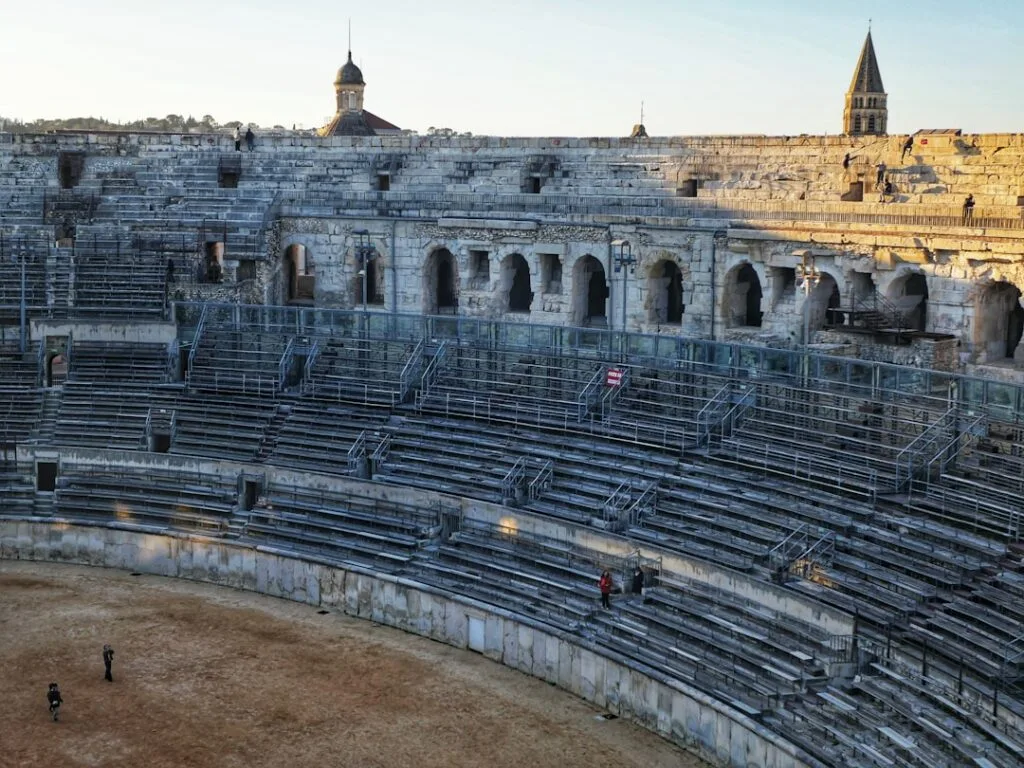 Ancient stone amphitheatre seating in Lecce with people on benches