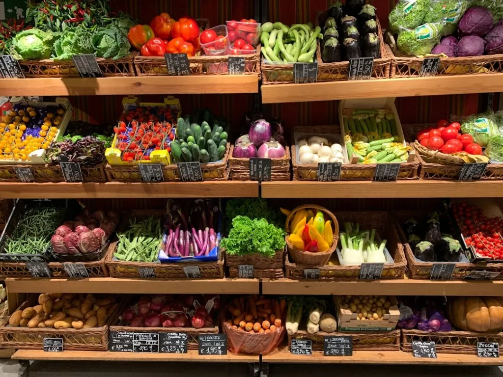 Étal intérieur soigné à Turin avec légumes en corbeilles et étiquettes