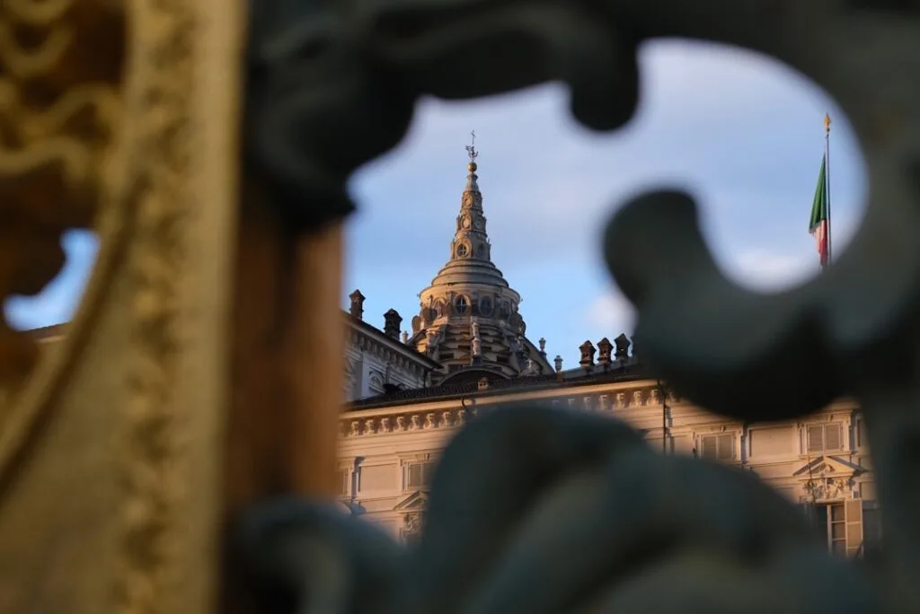 dôme d'un palais turinois visible à travers un motif de grille