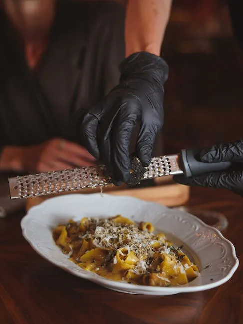 Serveur à Turin râpant une truffe noire sur des pâtes en salle