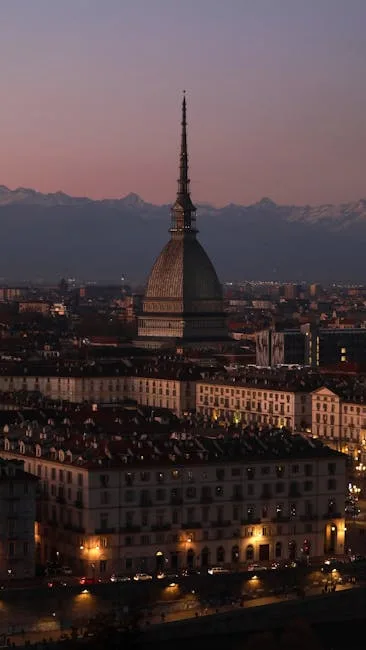 La Mole Antonelliana illuminée au crépuscule sur fond alpin à Turin