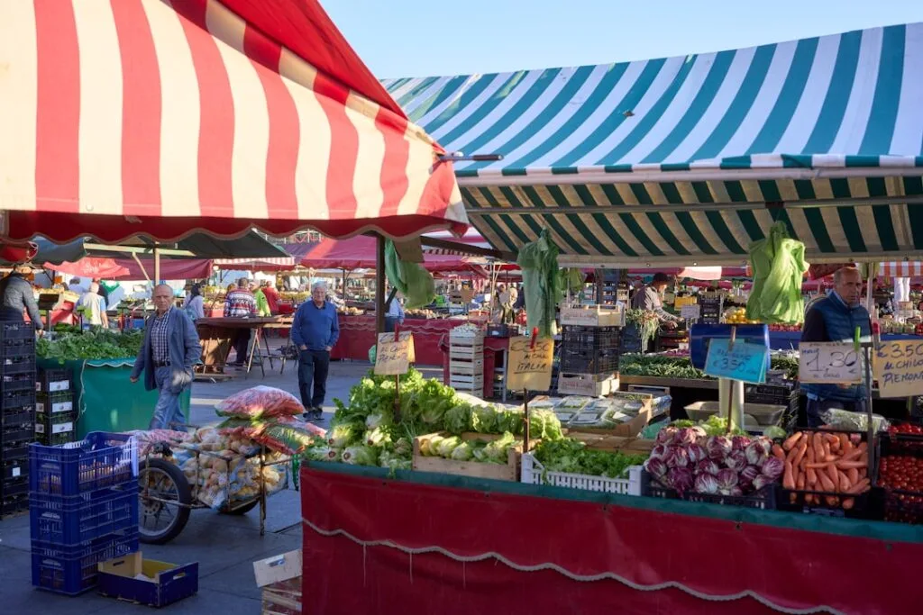Étals de marché à Turin avec nappes rayées et légumes variés