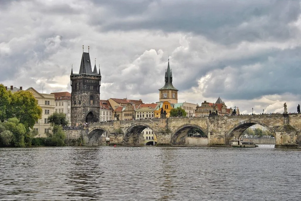 Pont de pierre historique avec tours médiévales et bateaux sur le fleuve