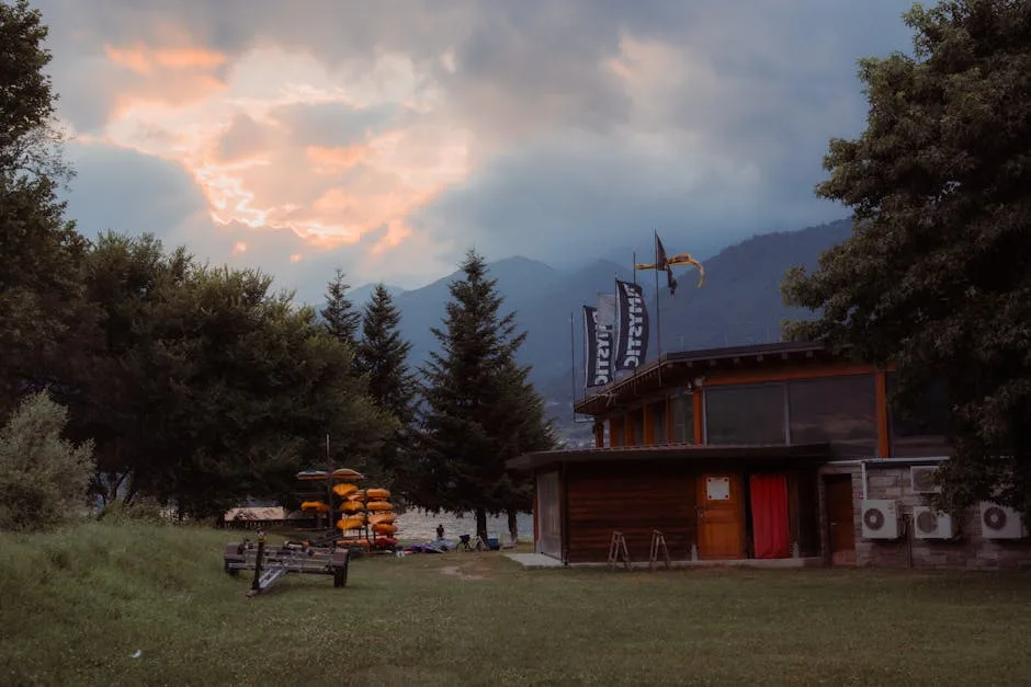Bâtiment en bois près d'un champ, rangée de kayaks orange empilés