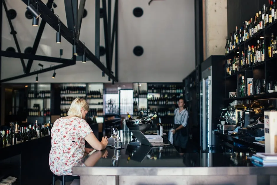 Client assis au bar moderne entouré d'étagères à vins, Turin