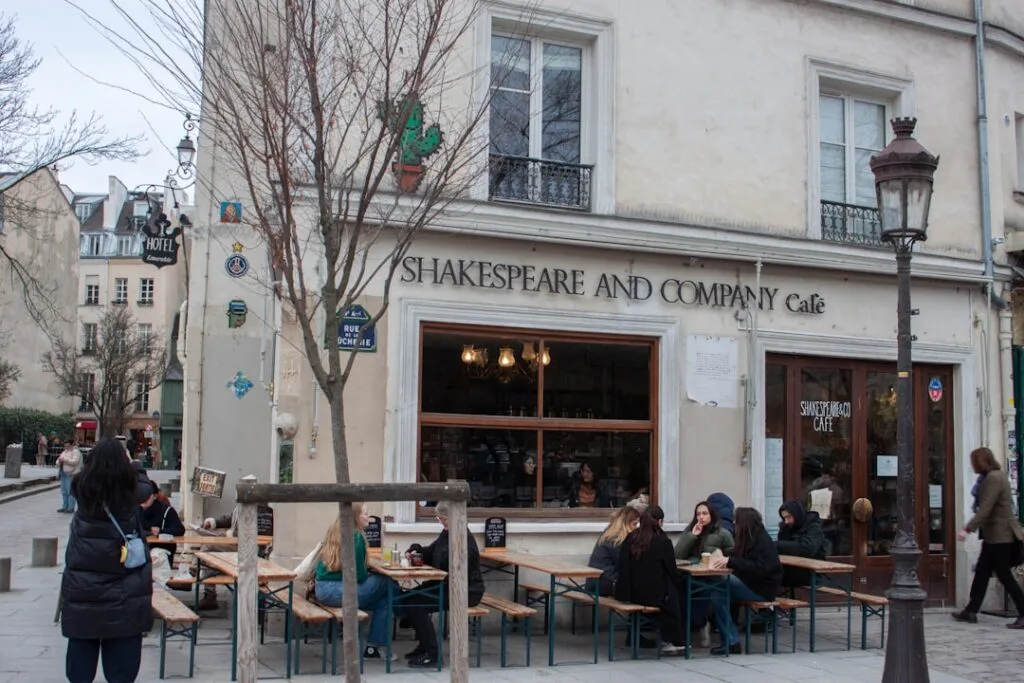 Café Shakespeare and Company avec tables extérieures et passants