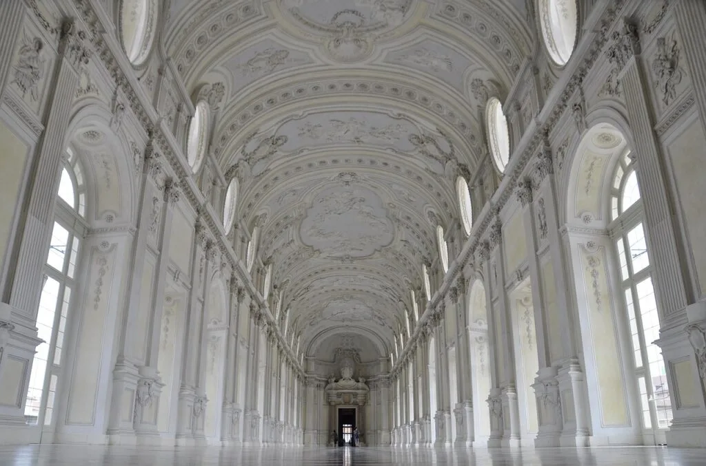 Galerie monumentale du palais de Turin, voûtes sculptées et fenêtres alignées.