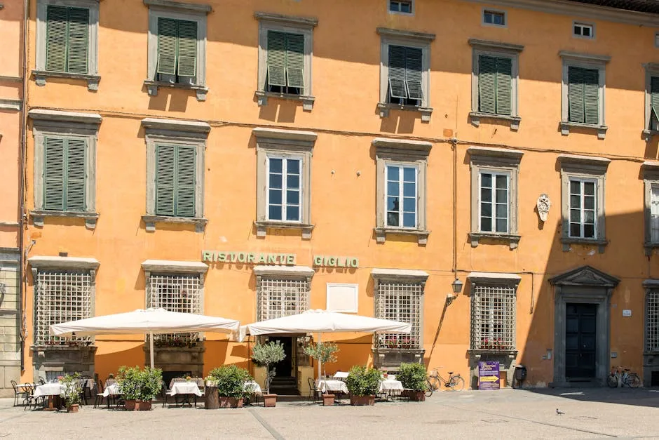 Terrasse de restaurant italien sous parasols devant façade ocre