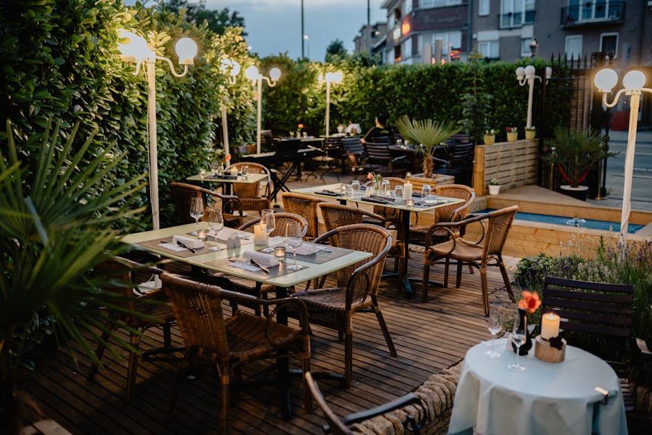 Terrasse de restaurant éclairée au crépuscule avec nappes et bougies