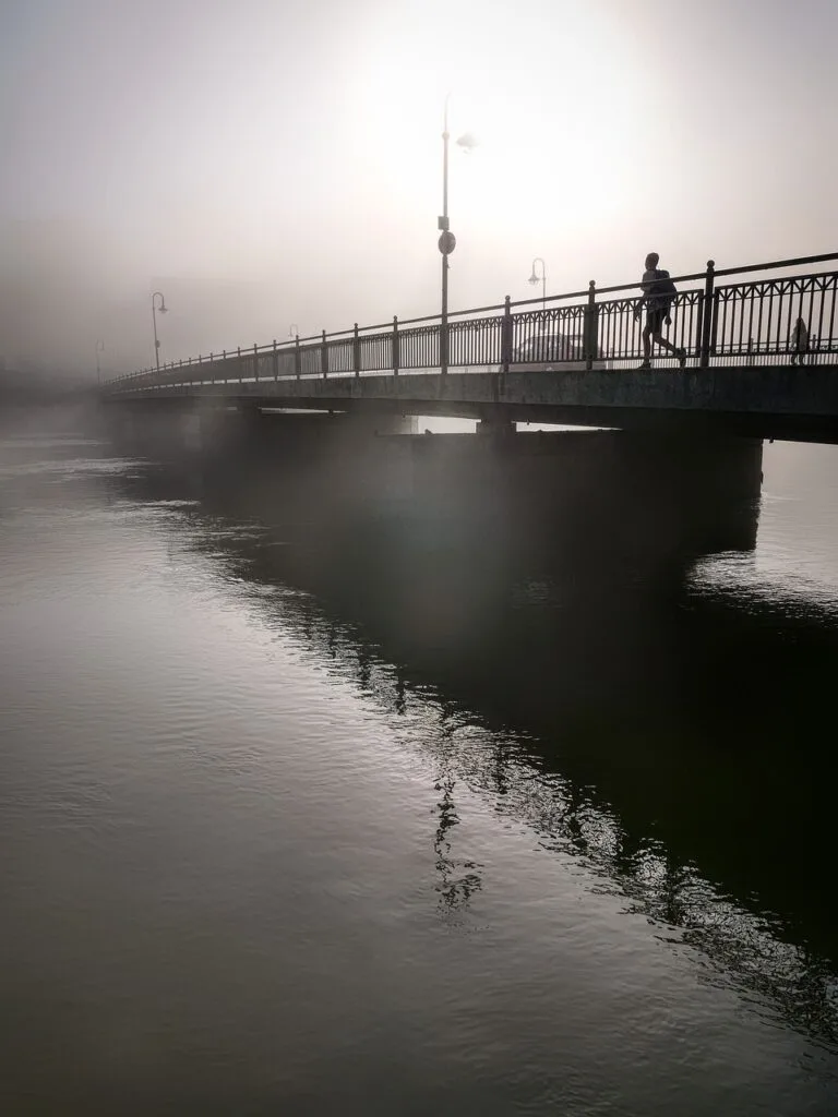 Joggeuse solitaire sur un pont brumeux au-dessus du Po à Turin