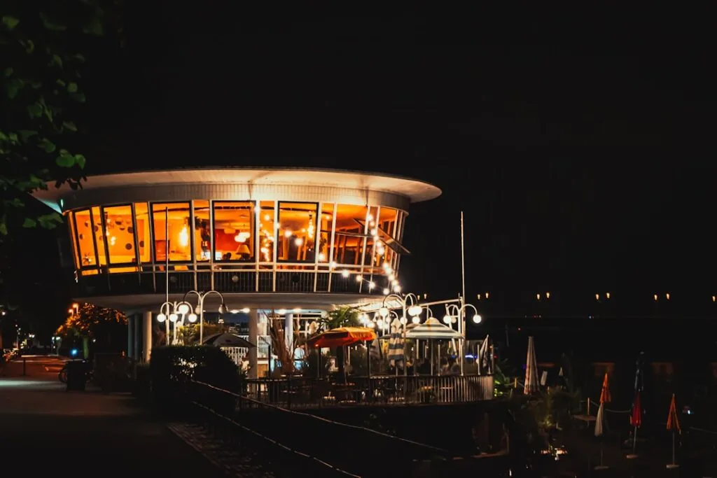 Rond bâtiment-restaurant éclairé sur les quais du fleuve à Turin.