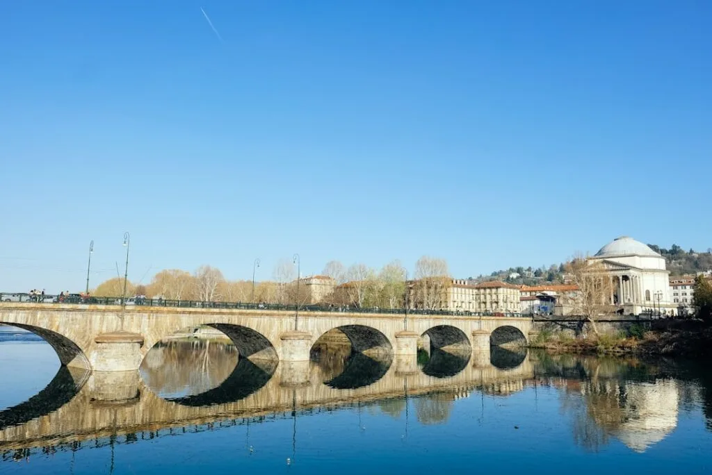Pont en arc reflété sur le fleuve, Gran Madre visible à Turin.