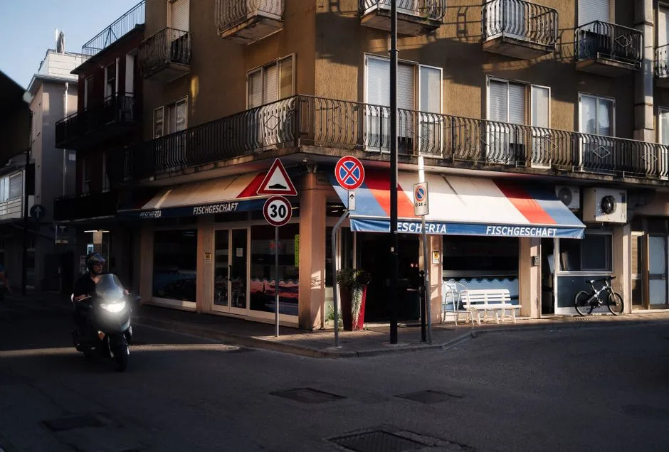 Façade d'une poissonnerie avec auvent rayé et scooter devant