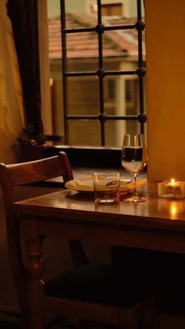 Table pour deux près d'une fenêtre grillagée, verre et bougie à Turin