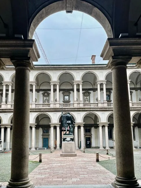 Cour intérieure à arcades avec statue au centre, Turin