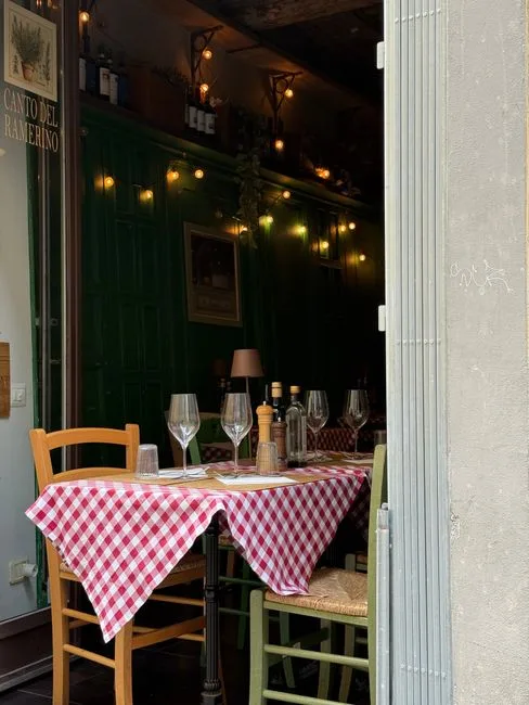 Table extérieure nappée vichy rouge prête pour dîner, devant restaurant turinois