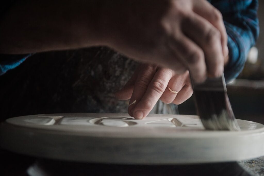artist glazing a ceramic piece