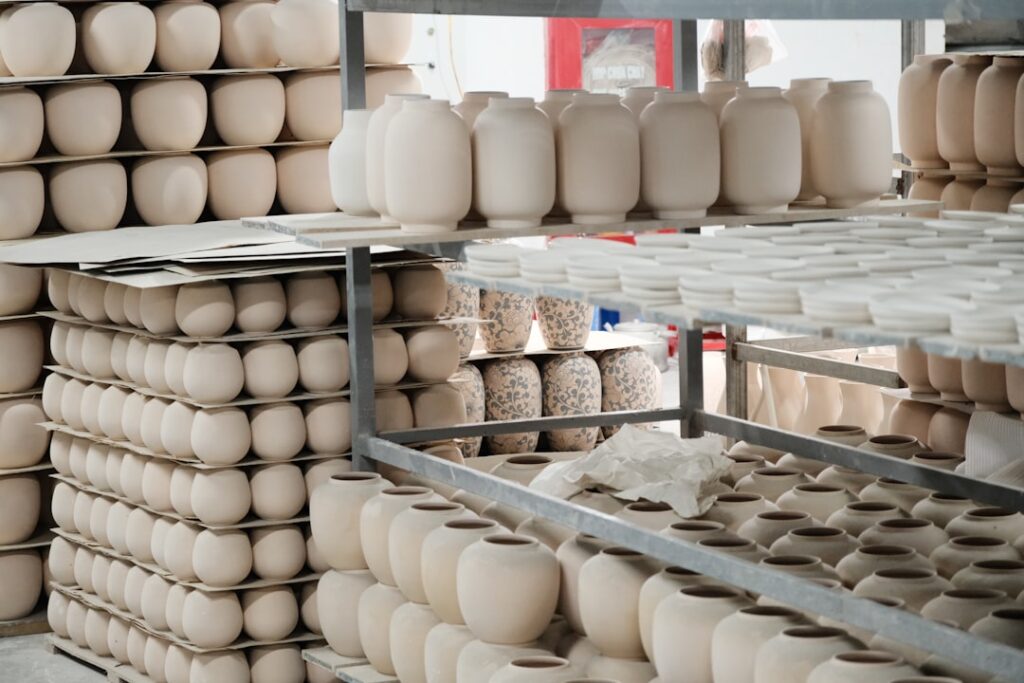 Ongeglazuurde witte vazen op rekken in keramiekatelier aan de Amalfikust