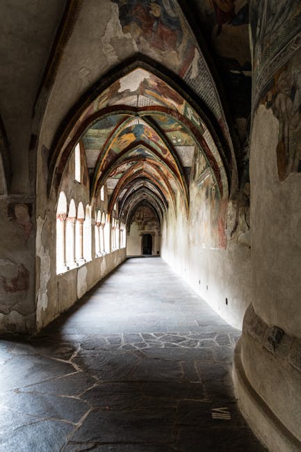 Langer gewölbter Kreuzgang mit Fresken und Licht durch Fenster