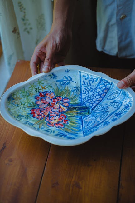Twee handen tonen handgeschilderde keramiekschaal met bloemen aan de Côte amalfitaine
