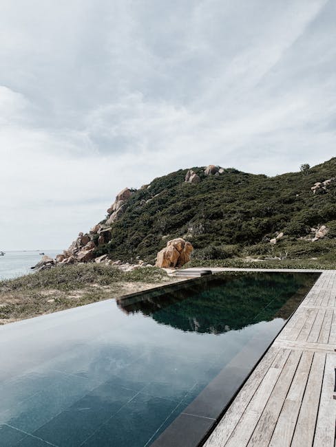 Minimal dark infinity pool beside wooden deck overlooking rocky headland on the Amalfi Coast