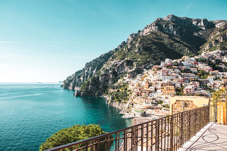 Wrought-iron terrace railing framing Positano's cliffside and turquoise Amalfi Coast sea