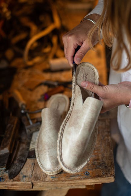 Hand eines Handwerkers näht Espadrilles aus Naturmaterialien in Amalfi, Côte amalfitaine.