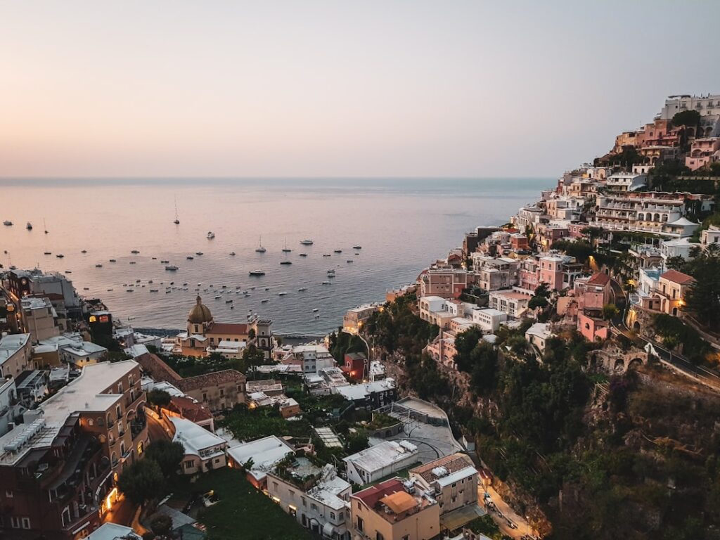 Terrassenhäuser klammern sich an Steilhang über dem Hafen von Positano, Côte amalfitaine