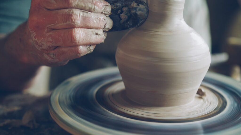 Potter shaping a spinning clay vase on the wheel in Amalfi Coast studio