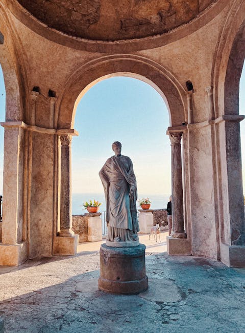 Statua classica sotto un arco con vista sul mare della Costiera Amalfitana