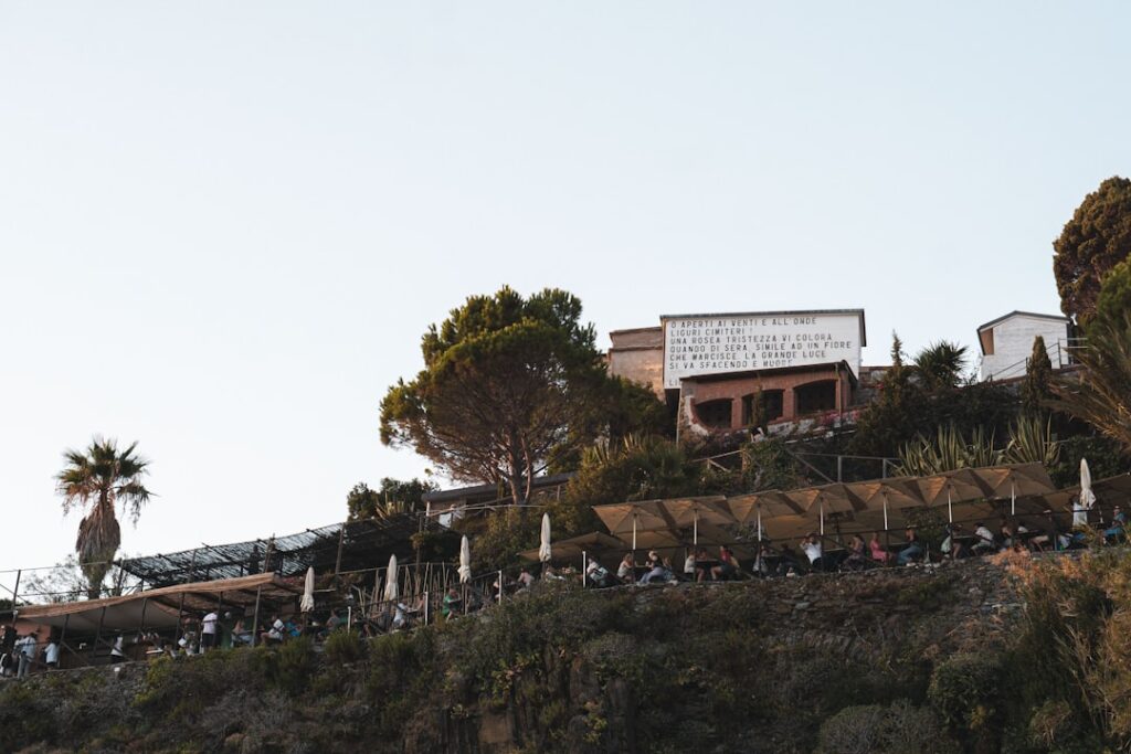 Clifftop terrace restaurant with umbrellas and diners overlooking the Amalfi Coast