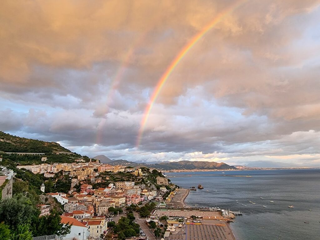 Dubbele regenboog boven een stad aan de Côte amalfitaine, kustzicht
