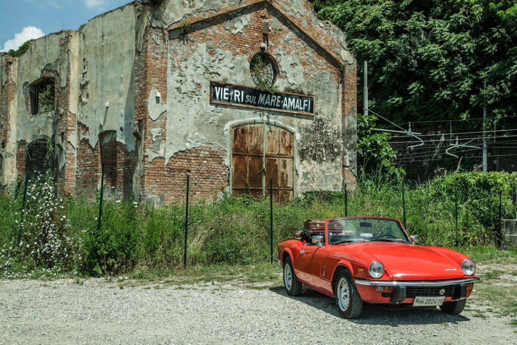 Rotes Cabrio vor verfallener Halle in Vietri sul Mare an der Côte amalfitaine.
