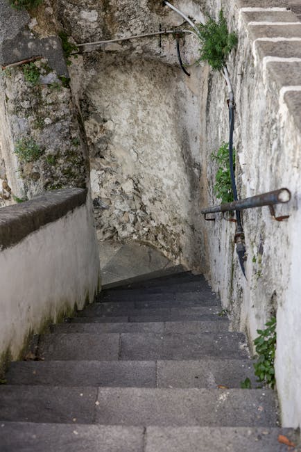 Scalinata in pietra che scende tra pareti rocciose sulla Costiera Amalfitana