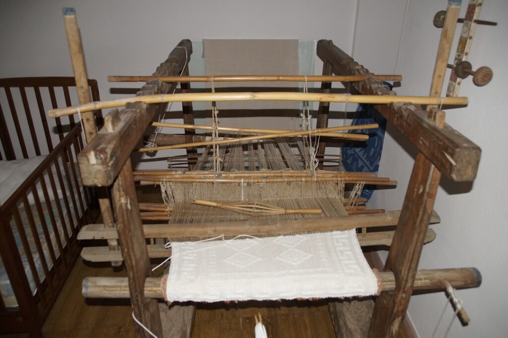 Alter Holzwebstuhl mit halbfertigem Leinentuch in einem Atelier der Amalfiküste
