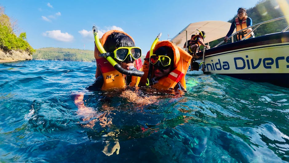 Coppia con maschere e giubbotti che fa snorkeling vicino a barca sulla Costiera Amalfitana