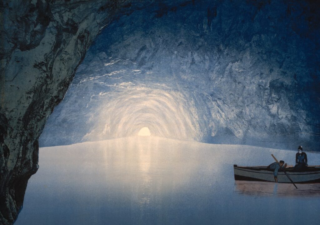 Interno di grotta azzurra con barca e luce distante sulla Costiera Amalfitana