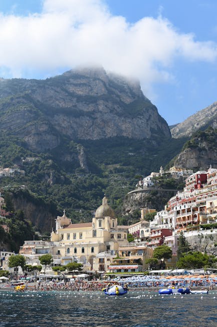 Crowded beach and domed cathedral beneath cliffs on the Amalfi Coast